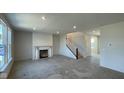 Bright living room with a fireplace, staircase, and large windows, ready for personalization and comfort at 6450 Stone Side Dr, Plainfield, IN 46168