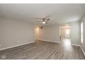 Bright living room with new gray flooring, a ceiling fan, neutral paint, and plenty of natural light at 671 Greenway St, Greenwood, IN 46143