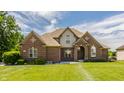 Charming brick two-story home with meticulous landscaping, a welcoming entrance, and a classic architectural style at 719 E New Rd, Greenfield, IN 46140
