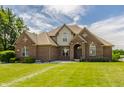 Charming brick two-story home with meticulous landscaping, a welcoming entrance, and a classic architectural style at 719 E New Rd, Greenfield, IN 46140