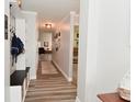 Inviting hallway featuring wood-look floors and mud room with storage and decorative wall decor at 7515 Brattle Dr, Indianapolis, IN 46113