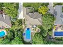 Aerial view showcases the house, the sparkling pool with lounge area, and mature trees surrounding the property at 790 Foxboro Dr, Avon, IN 46123