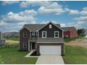 Inviting home showcasing a blend of brick and siding, along with a well-maintained lawn and attached garage at 808 Capricorn Dr, Franklin, IN 46131