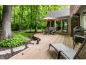 Tranquil backyard deck with an umbrella table, a brick chimney and lush greenery at 9445 Moorings Blvd, Indianapolis, IN 46256