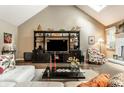 Cozy living room featuring vaulted ceilings, a modern entertainment center, and comfortable seating at 9445 Moorings Blvd, Indianapolis, IN 46256