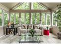 Bright sunroom with tiled floor, large windows and comfortable seating area surrounded by lush greenery at 9445 Moorings Blvd, Indianapolis, IN 46256