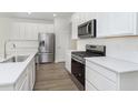 Modern kitchen with stainless steel appliances, white cabinets, and stylish backsplash at 9741 Oleander Dr, Fishers, IN 46250