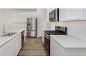 Modern kitchen featuring stainless steel appliances, white countertops, cabinetry, and hardwood flooring at 9741 Oleander Dr, Fishers, IN 46250