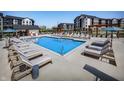 Luxury apartment community pool area featuring ample lounge chairs and umbrellas under a clear sky at 9741 Oleander Dr, Fishers, IN 46250