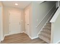 Bright foyer featuring hardwood flooring, staircase, and a white front door for a welcoming entrance at 10431 Bellchime Ct, Indianapolis, IN 46235