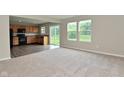 Open concept living room and kitchen area with lots of natural light, carpet, and hardwood flooring at 10431 Bellchime Ct, Indianapolis, IN 46235