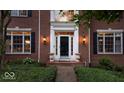 Close-up of front entrance with black door, sidelights, and elegant sconces at 11227 Woods Bay Ln, Indianapolis, IN 46236