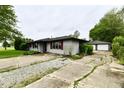Single-story home featuring a detached two car garage and a cracked concrete driveway at 11309 N County Road 750 W, Elwood, IN 46036