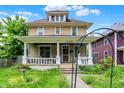 Attractive two-story home with a covered front porch, landscaped yard, and traditional architectural style at 1138 N Oxford St, Indianapolis, IN 46201
