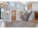 Spacious foyer featuring a grand staircase, hardwood floors, and an elegant front door at 11404 Hanbury Manor Blvd, Noblesville, IN 46060
