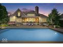 Backyard with a sparkling pool, patio with seating, and manicured landscaping at 11404 Hanbury Manor Blvd, Noblesville, IN 46060