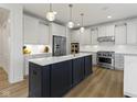 Stunning kitchen with a large island, white cabinets, stainless steel appliances, and hardwood floors at 11984 Talnuck Cir, Fishers, IN 46037