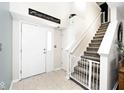 Bright entryway featuring tiled floor, stairway with safety gate and a white front door at 1222 Grand Canyon Ct, Franklin, IN 46131