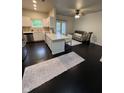 Bright living room featuring dark wood floors, open layout to kitchen, and doors to the outside at 12853 Tradd St # 2B, Carmel, IN 46032