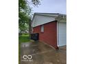 Side of red brick house with white siding, green lawn, and paved area at 1308 N Main St, Lapel, IN 46051