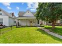 Exterior view of the home with a well-manicured lawn, black fence and lovely landscaping at 1627 Pleasant St, Indianapolis, IN 46203