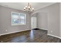 Elegant dining room with modern chandelier, wood floors, neutral paint, and plenty of natural light at 1704 Beach St, Greenwood, IN 46143