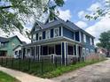Picture of a two-story blue home with white trim and a black metal fence at 201 N Tacoma Ave, Indianapolis, IN 46201