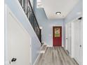 Inviting entryway with wood floors, stairs, and bright red door at 2429 N Centennial St, Indianapolis, IN 46222