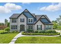 Charming two-story home with manicured lawn, brick accents and mature trees at 2485 Alexandra Dr, Carmel, IN 46074