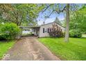 Single-story home with driveway and carport nestled on a well-maintained lawn with mature landscaping at 3801 N Vernon Dr, Muncie, IN 47304