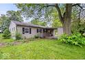 Single-story home with driveway and carport nestled on a well-maintained lawn with mature landscaping at 3801 N Vernon Dr, Muncie, IN 47304
