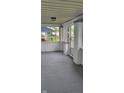 Enclosed front porch with paneled windows, painted columns, and a neutral floor, enhancing the home's curb appeal at 427 N Alton Ave, Indianapolis, IN 46222