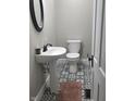 Stylish powder room features a pedestal sink, toilet, and patterned tile flooring at 4303 W County Road 200 S Rd, Danville, IN 46122