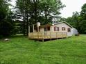 The home offers a large, inviting wooden deck surrounded by lush green landscaping and mature trees at 4675 N Herbemont Rd, Martinsville, IN 46151