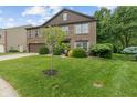 Manicured front yard with a young tree and verdant lawn leading to a traditional brick two-story home at 5640 High Vista Cir, Indianapolis, IN 46234