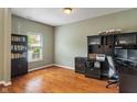 Home office with dark wood cabinets, desk, and hardwood floors bathed in natural light at 5640 High Vista Cir, Indianapolis, IN 46234