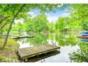 Scenic lake view with a dock and lush greenery, perfect for outdoor activities and relaxation at 5739 Paradise Dr, Martinsville, IN 46151