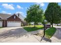 Desirable property showcasing a well-kept lawn, mature trees, and charming curb appeal at 6105 Franklin Villas Way, Indianapolis, IN 46237
