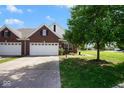 Well-maintained brick home with a two-car garage, green lawn, and inviting curb appeal at 6105 Franklin Villas Way, Indianapolis, IN 46237
