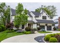 A beautiful two-story home with a circular driveway, landscaping, and a two-car garage at 6450 Holliday E Dr, Indianapolis, IN 46260