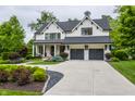 Beautiful two-story white home boasting an attached two-car garage, driveway, and manicured front yard at 6450 Holliday E Dr, Indianapolis, IN 46260