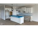 Modern kitchen with white cabinets, subway tile backsplash, and island with counter seating is a chef's dream at 6462 Stone Side Dr, Plainfield, IN 46168