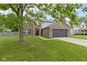Two-story brick home featuring an attached two-car garage and well-maintained front lawn at 65 Millet Ct, Danville, IN 46122