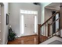 Bright foyer with hardwood floors, staircase, and elegant white front door with sidelights at 6649 Braemar S Ave, Noblesville, IN 46062