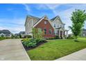 Beautifully landscaped home featuring a spacious lawn, lush green trees, and a long drive at 7046 Allegiance Ct, Indianapolis, IN 46259