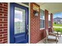Inviting front porch with seating, a decorative sign, and a stylish blue front door at 7046 Allegiance Ct, Indianapolis, IN 46259