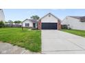 Exterior view of home displaying attached garage, walkway, and front yard at 7319 Jackie Ct, Indianapolis, IN 46221