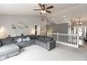 Cozy living room featuring vaulted ceilings, a large gray sofa, and neutral decor at 8084 Lawrence Woods Pl, Indianapolis, IN 46236