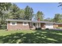 Lovely brick ranch with a well-maintained front lawn, attached garage, and charming front porch at 8246 S Franklin Rd, Indianapolis, IN 46259