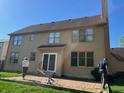 A two-story home back view with a brick patio and expansive windows at 8400 Harrison Pkwy, Fishers, IN 46038